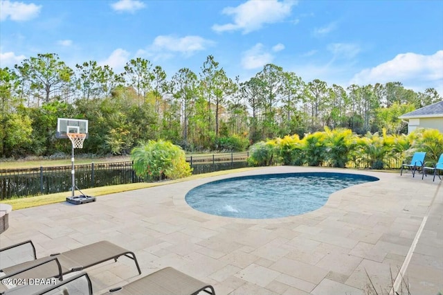 view of pool featuring a patio area and a water view