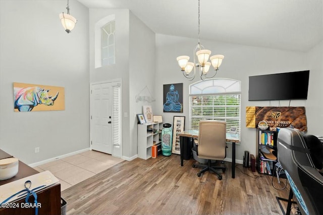 home office featuring hardwood / wood-style flooring, high vaulted ceiling, and a notable chandelier