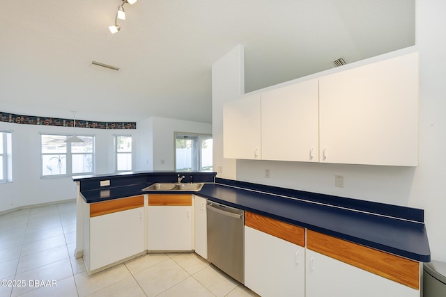 kitchen with dishwasher, a peninsula, light tile patterned floors, and a sink