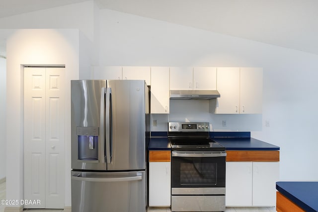 kitchen with dark countertops, under cabinet range hood, lofted ceiling, appliances with stainless steel finishes, and white cabinetry