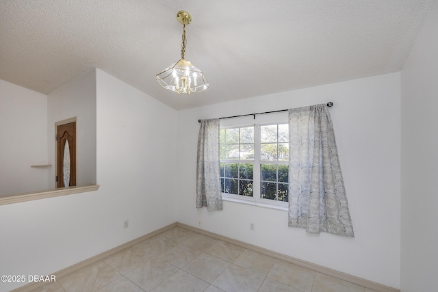 empty room featuring baseboards, light tile patterned flooring, vaulted ceiling, a textured ceiling, and a chandelier