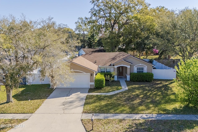 view of front of house featuring stucco siding, a front lawn, fence, concrete driveway, and an attached garage