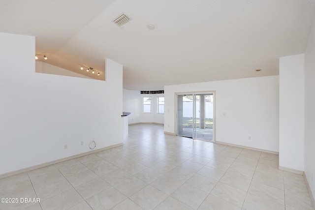 unfurnished room featuring light tile patterned floors, visible vents, baseboards, and vaulted ceiling