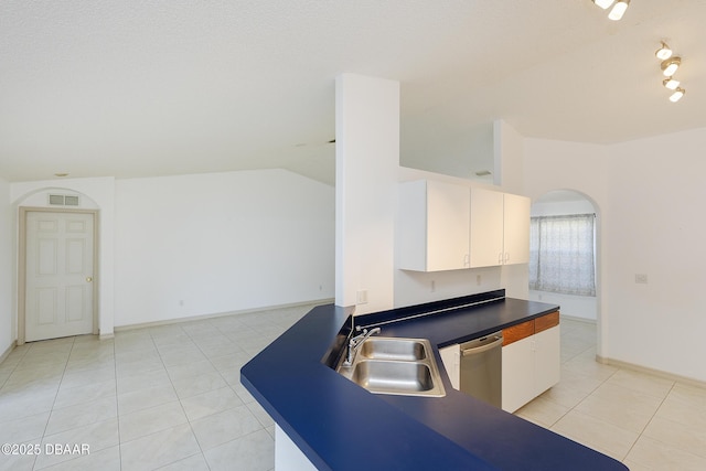 kitchen with visible vents, lofted ceiling, a sink, stainless steel dishwasher, and dark countertops