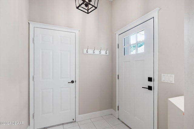 doorway to outside featuring light tile patterned floors and a notable chandelier