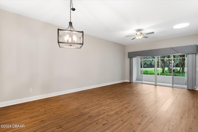 empty room featuring wood-type flooring and ceiling fan with notable chandelier