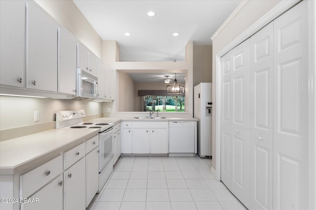 kitchen with light tile patterned floors, white appliances, white cabinetry, and sink