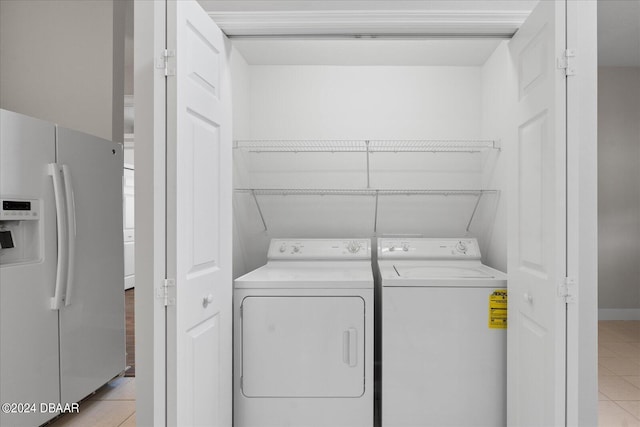 laundry room with light tile patterned floors and washer and clothes dryer