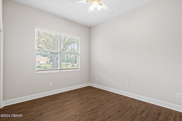 empty room with ceiling fan and dark hardwood / wood-style flooring