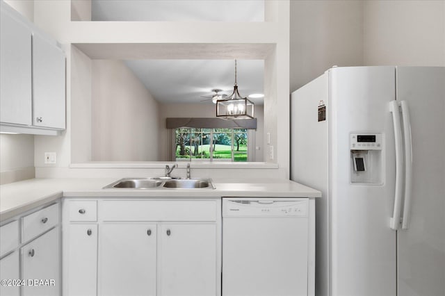 kitchen featuring sink, white cabinets, hanging light fixtures, and white appliances