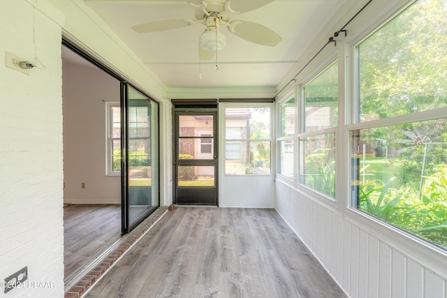 unfurnished sunroom with ceiling fan