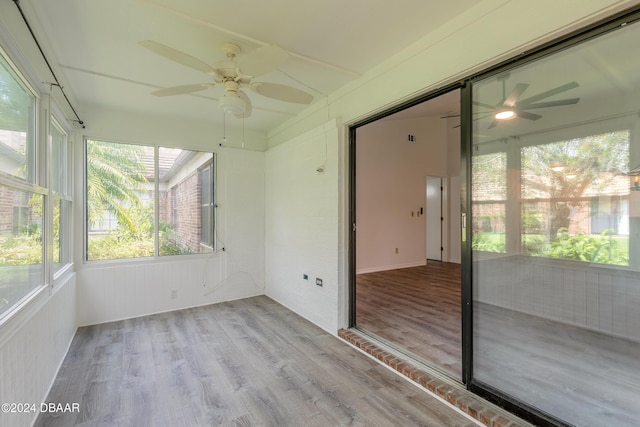 unfurnished sunroom featuring ceiling fan and a healthy amount of sunlight