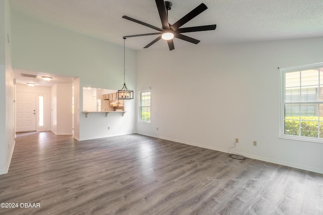 unfurnished living room featuring high vaulted ceiling, hardwood / wood-style floors, and ceiling fan