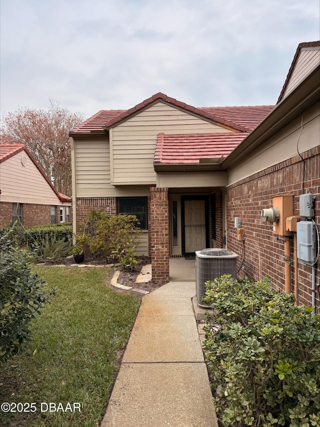 property entrance with a yard and central air condition unit