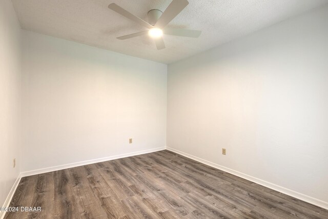 empty room featuring dark hardwood / wood-style flooring, a textured ceiling, and ceiling fan