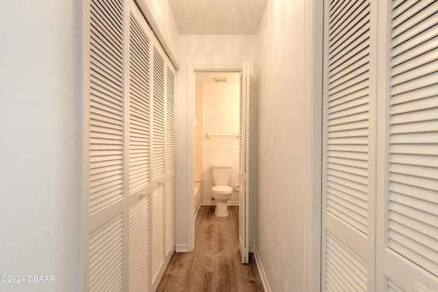 hall featuring a textured ceiling and hardwood / wood-style flooring