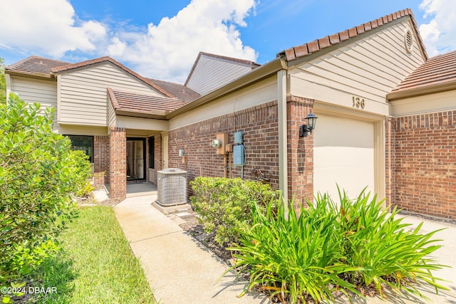 view of front of property featuring cooling unit and a garage