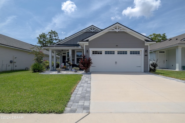 craftsman-style home featuring a garage, covered porch, and a front lawn