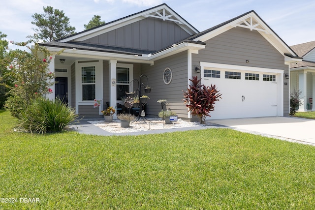 view of front of house with a garage, a front lawn, and covered porch