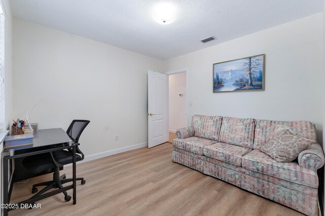 3167 S Peninsula Dr, Daytona Beach, FL 32118 - office area with light wood-type flooring, visible vents, baseboards, and a textured ceiling