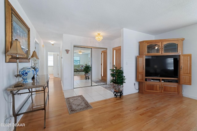 3167 S Peninsula Dr, Daytona Beach, FL 32118 - entrance foyer featuring baseboards, a ceiling fan, light wood-type flooring, and a textured ceiling