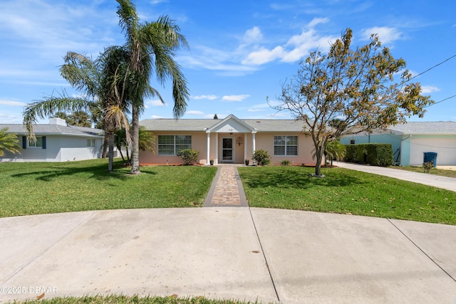 3167 S Peninsula Dr, Daytona Beach, FL 32118 - ranch-style house with a front lawn, concrete driveway, and stucco siding