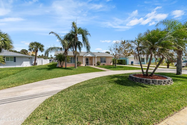 3167 S Peninsula Dr, Daytona Beach, FL 32118 - ranch-style home featuring stucco siding, fence, a front lawn, and curved driveway