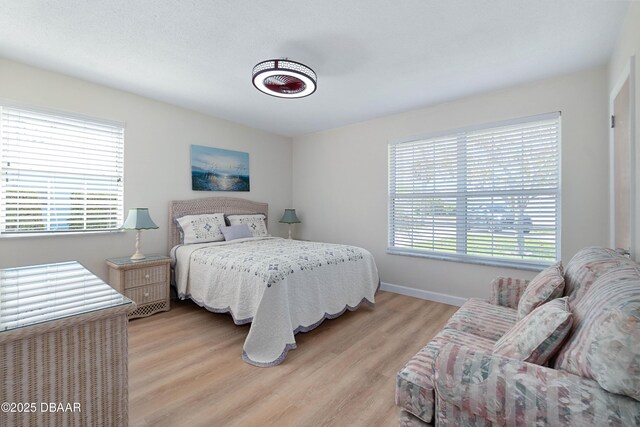 3167 S Peninsula Dr, Daytona Beach, FL 32118 - bedroom featuring baseboards, multiple windows, and light wood-style floors