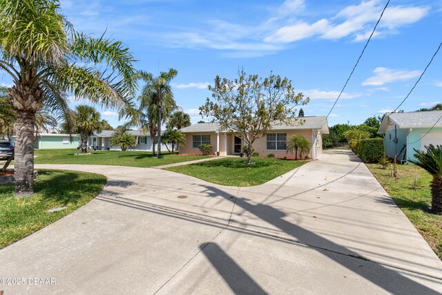 3167 S Peninsula Dr, Daytona Beach, FL 32118 - view of front facade featuring a front yard, stucco siding, and curved driveway