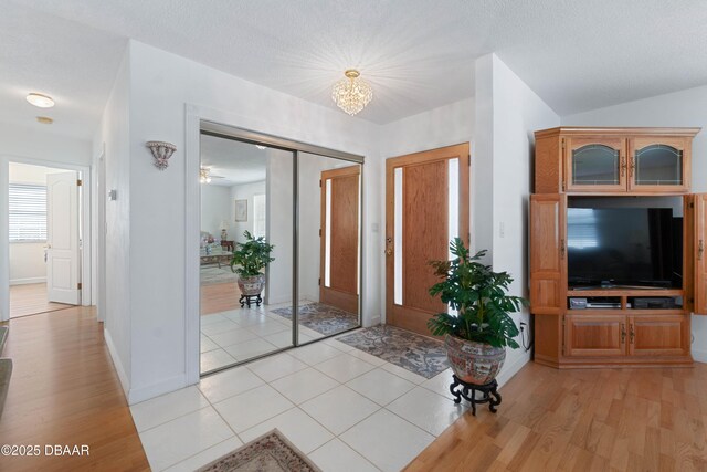 3167 S Peninsula Dr, Daytona Beach, FL 32118 - foyer entrance featuring an inviting chandelier, light wood-style floors, baseboards, and a textured ceiling