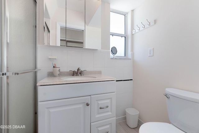 3167 S Peninsula Dr, Daytona Beach, FL 32118 - bathroom with tile walls, toilet, and vanity