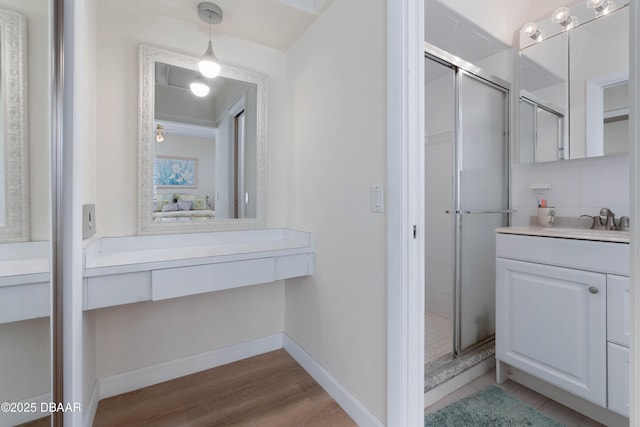 3167 S Peninsula Dr, Daytona Beach, FL 32118 - bathroom with a stall shower, vanity, baseboards, and wood finished floors