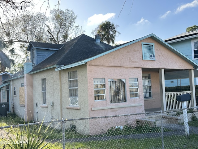 exterior space featuring a fenced front yard, stucco siding, and a chimney