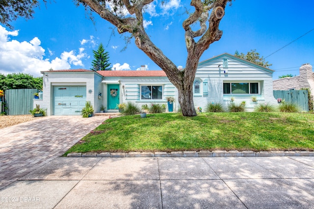 single story home with a garage and a front lawn