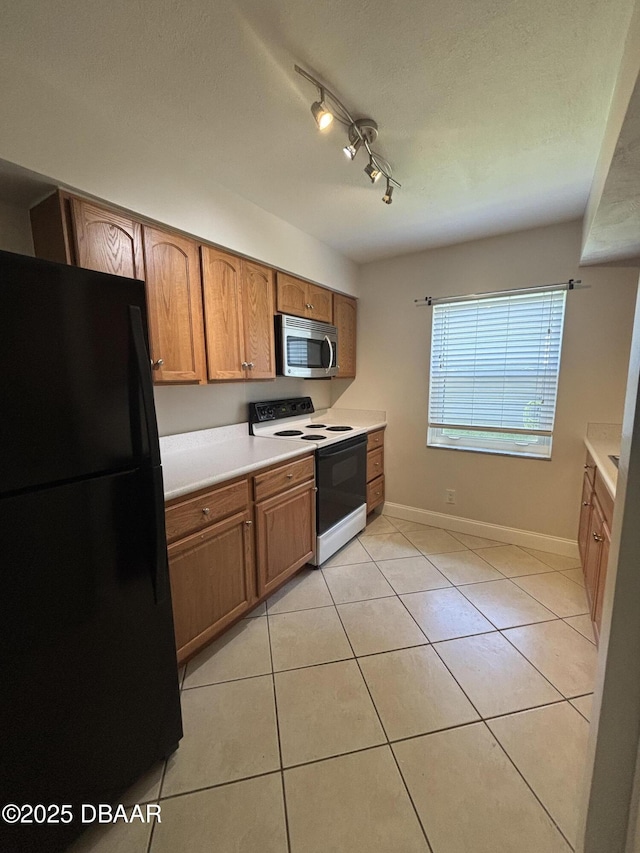 917 Royal Oak Ct, Holly Hill, FL 32117 - kitchen with white electric range oven, freestanding refrigerator, stainless steel microwave, light countertops, and brown cabinetry