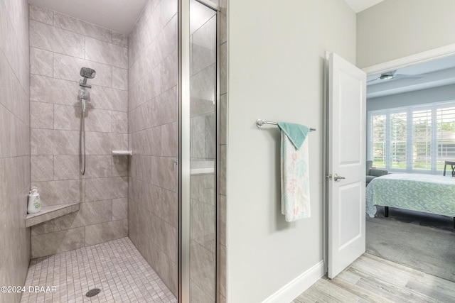 bathroom featuring hardwood / wood-style flooring and a tile shower