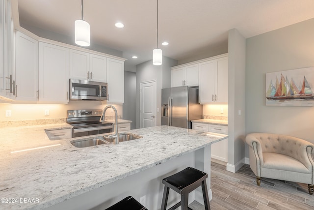 kitchen featuring white cabinetry, pendant lighting, and appliances with stainless steel finishes