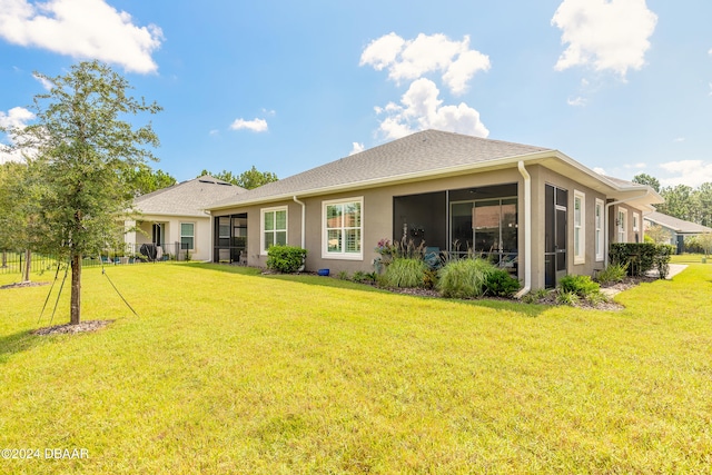 back of house featuring a sunroom and a yard