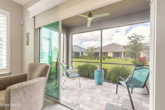 sunroom featuring ceiling fan and plenty of natural light