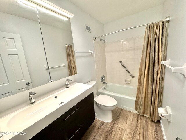 full bathroom featuring toilet, vanity, shower / bath combination with curtain, and wood-type flooring