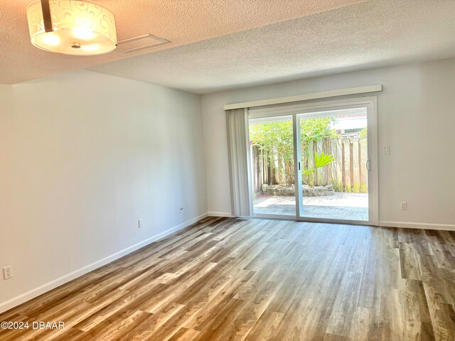 unfurnished room featuring a textured ceiling and hardwood / wood-style flooring