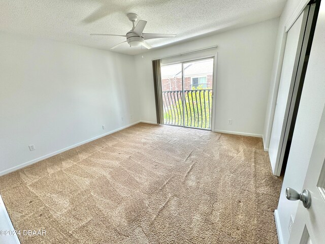 unfurnished room featuring ceiling fan, a textured ceiling, and carpet floors