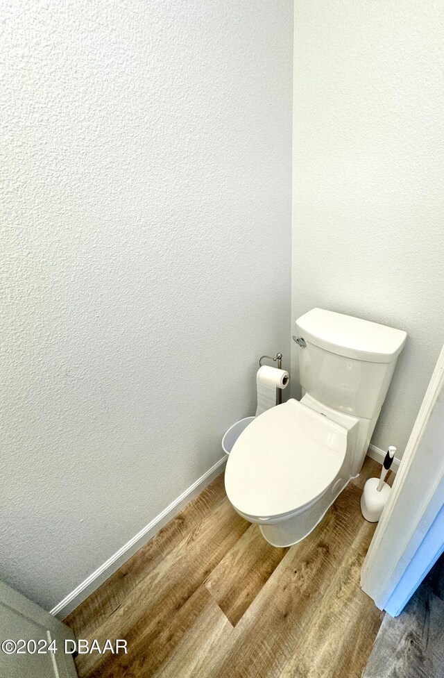 bathroom featuring wood-type flooring and toilet