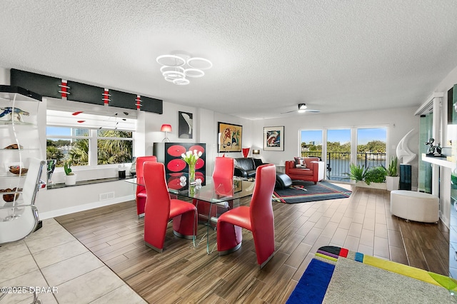 dining area featuring ceiling fan and a textured ceiling