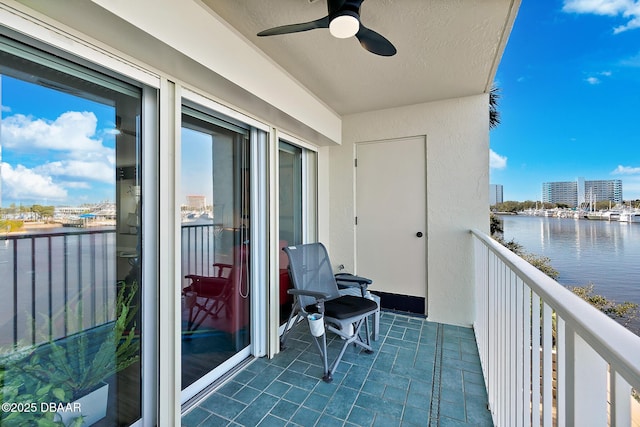 balcony featuring a water view and ceiling fan