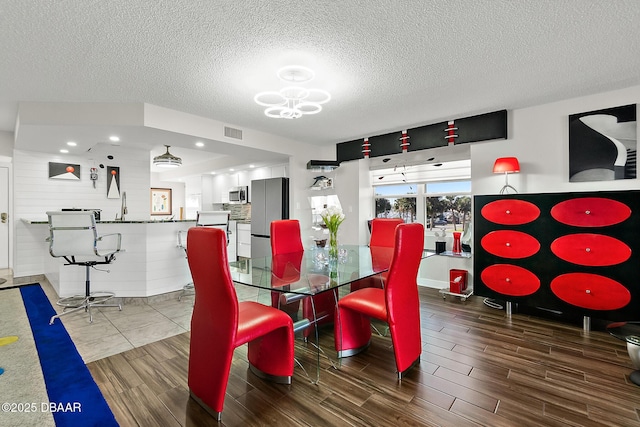 dining space with a notable chandelier and a textured ceiling