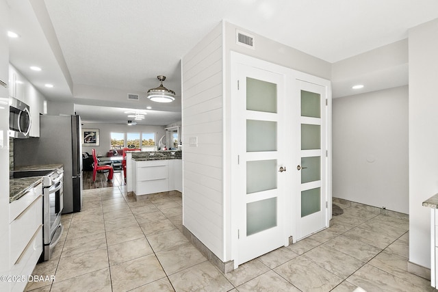 kitchen with white cabinetry, stainless steel appliances, and light tile patterned floors