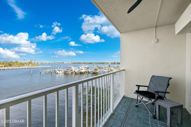 balcony with a water view and ceiling fan