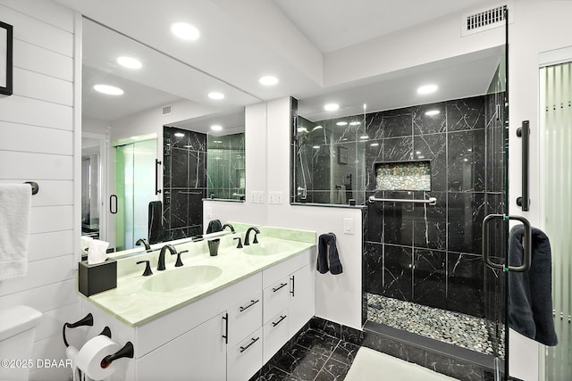 bathroom with vanity, a shower with shower door, and toilet