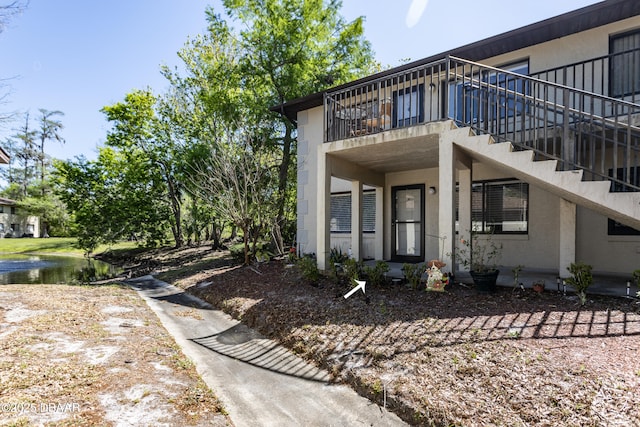 view of side of property featuring a water view and stucco siding